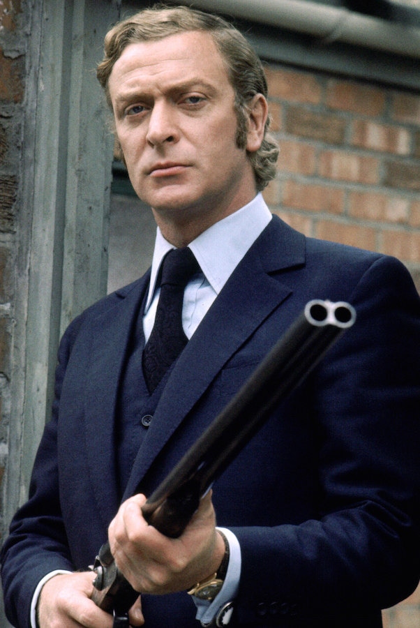 Michael Caine as Jack Carter in Get Carter, 1971. Caine’s iconic blue worsted three-piece suit is paired with a stiff-collar light blue shirt and midnight blue tie.