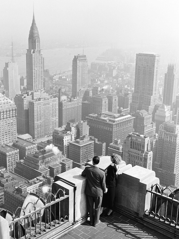 View of a couple sightseeing in New York, looking through  a viewscope down on the city skyline, 1948. The Chrysler building is visible on the left. (Photo by Rae Russel/Getty Images).