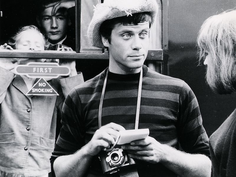 Reed wears a straw cowboy hat, striped sweater and carries a classic manual film camera as Tinker the tourist photographer in British drama The System, 1964. Photograph by British Lion/Bryanston/Kobal/REX/Shutterstock.