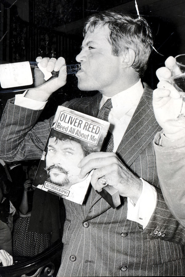 Reed at the launch of his book, ‘Reed All About Me’, with his staple drink in hand, 1979. Photograph by Bill Cross/Daily Mail/REX/Shutterstock.