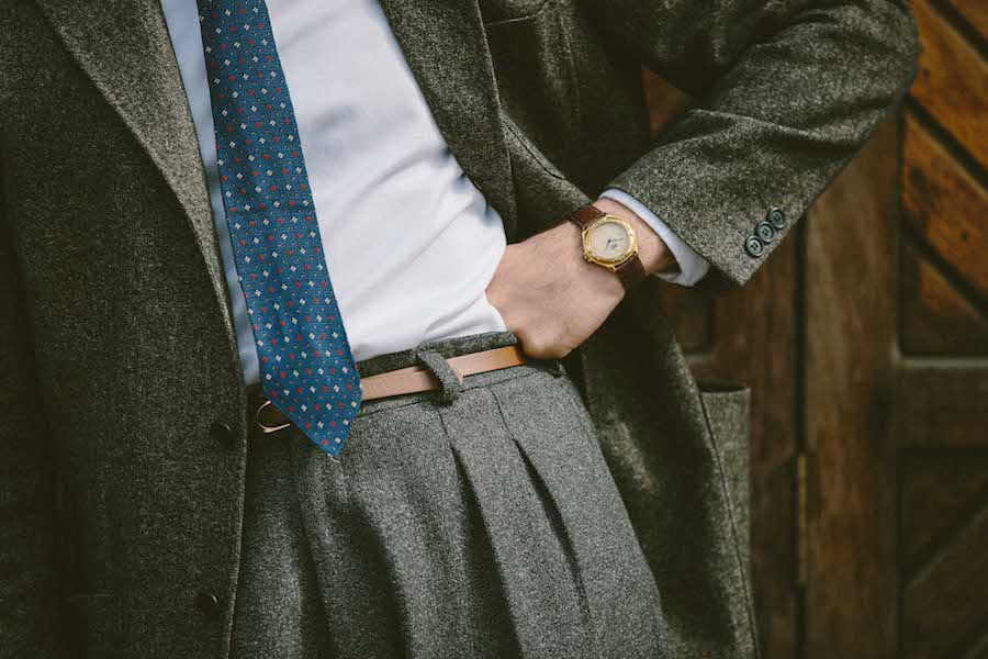 London-born tailor James Turner wears a grey wool and cashmere blend jacket with three buttons on the sleeve over a classic Oxford shirt with pleated cuffs. He has turned the shirt sleeves back once as an intentional sartorial twist and paired the ensemble with a vintage rose gold watch with a brown leather strap. Photograph by Jamie Ferguson.