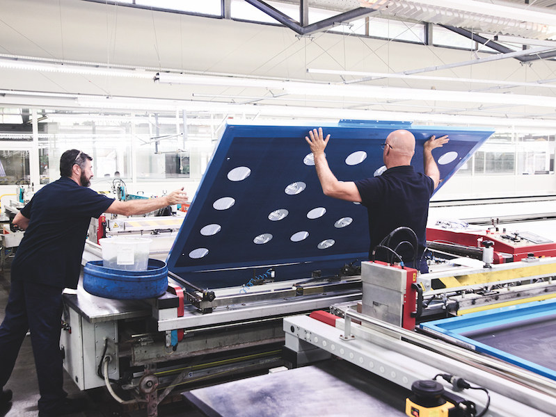 Two workmen carefully handling the heavy screens. Photograph by Kim Lang.