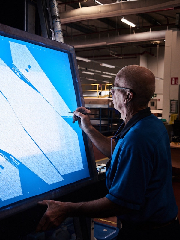 A craftsman inspecting a screen for potential defects. Photograph by Kim Lang.