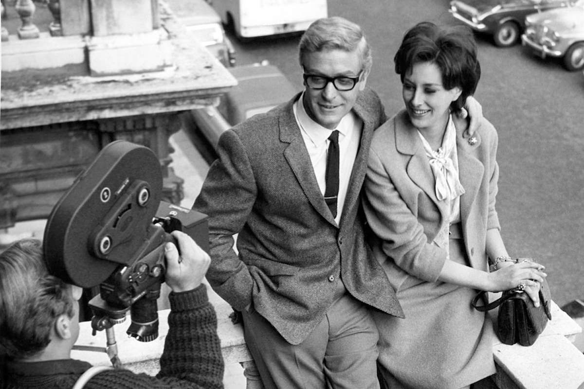 Michael Caine with his arm around the beautiful Sue Lloyd during the filming of The Ipcress File, circa 1965.