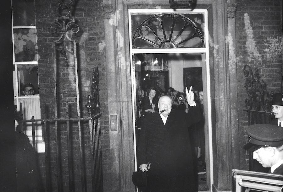 With his fingers raised in the familiar V sign, Churchill leaves No.10 Downing Street for the last time, 1955.