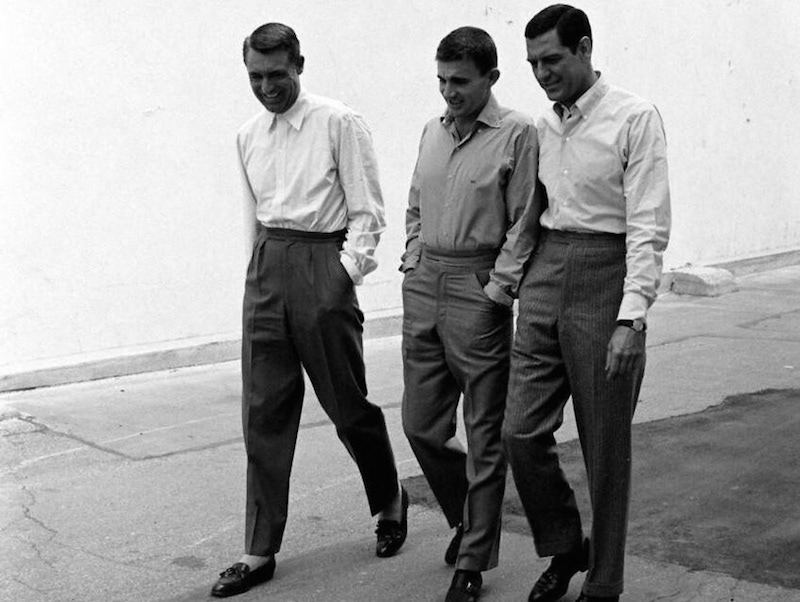 Famous for his elegant, full-cut suits, Cary Grant here shuns the tie, and wears his wide-legged, twin pleaters with a white shirt and tassel loafers, circa 1950s.