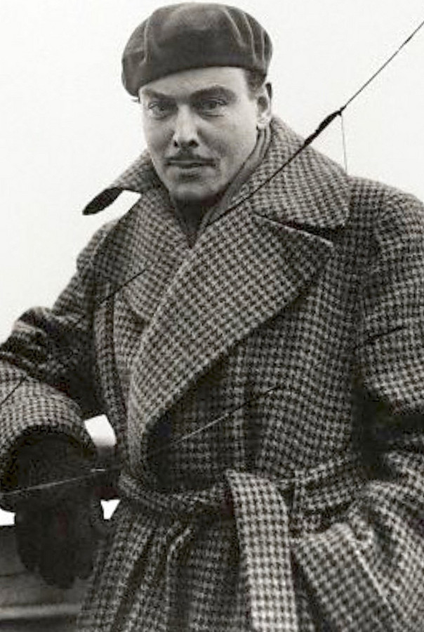 Nils Asther wearing an oversized trench-style coat in a houndstooth wool, complete with large lapels and a belted waist, 1935.