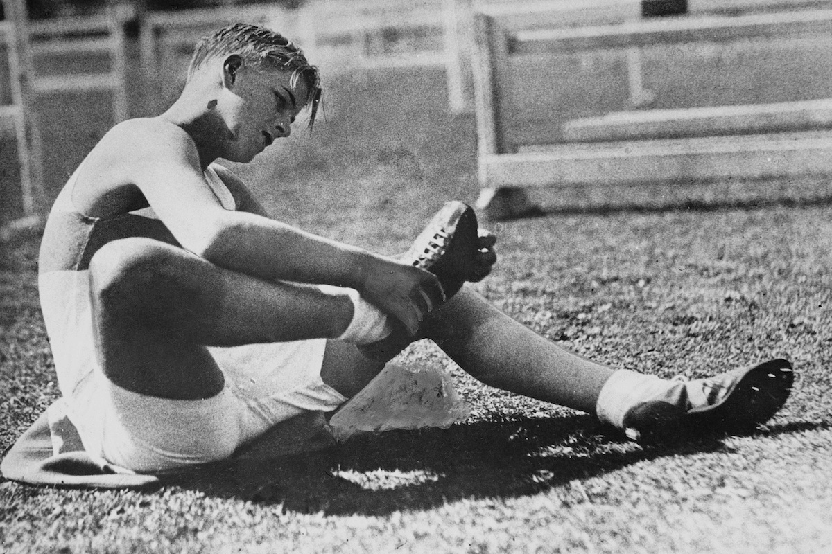 Prince Philip checks the spikes of his running shoes before taking part in an inter-schools sports day in 1935. (Photo by Paul Popper/Popperfoto/Getty Images)