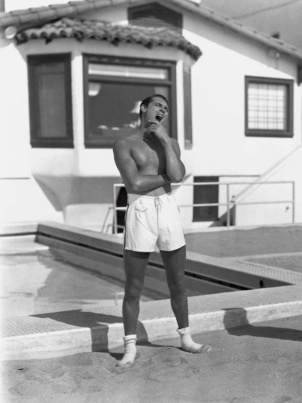 Cary Grant takes a break from his workout wearing crisp white shorts with a flap pocket and dark stripe down the side.