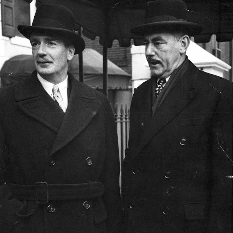 British Foreign Secretary Anthony Eden wears a double-breasted belted overcoat and bowler hat accompanied by the American Secretary of State, Dean Acheson in London, 1952.