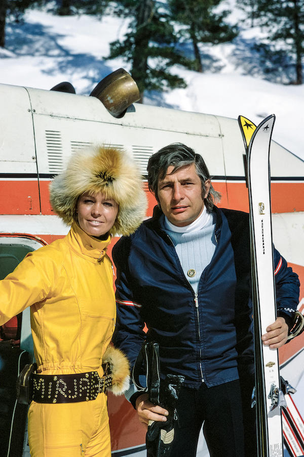 Gunter Sachs looks polished in a navy fitted ski jacket with a pale blue and white two-tone rollneck at the Swiss ski resort of St. Moritz with his wife Mirja Larsso, circa 1972.