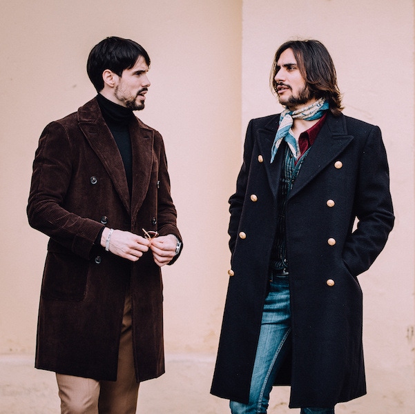 Sergio Guardi of Barbenera in a naval bridge coat, talks with a friend in a sumptuous corduroy double-breasted overcoat.