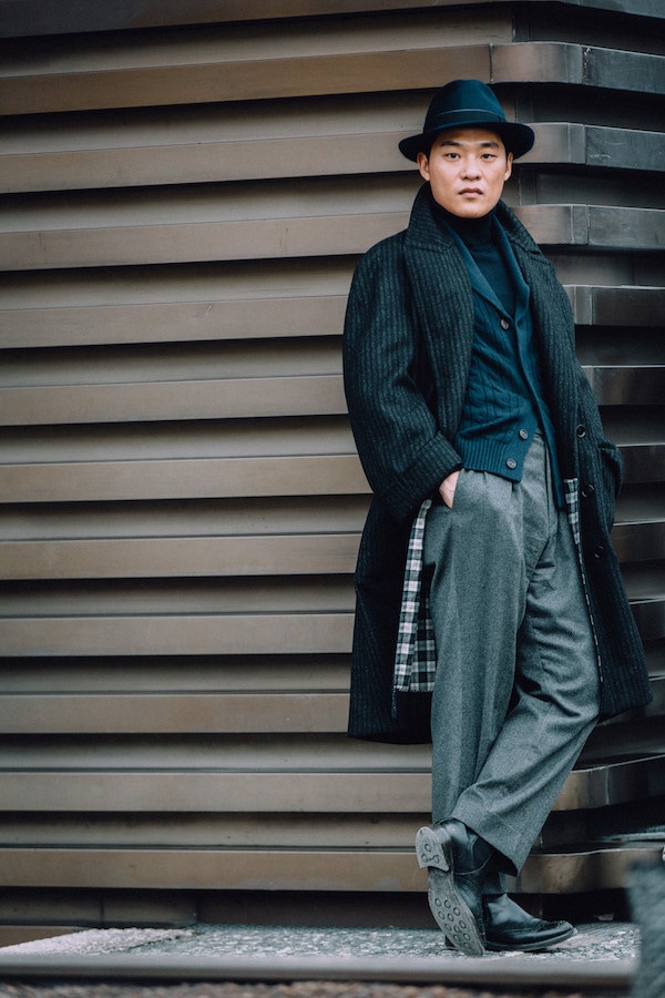 A relaxed, tonal look comprising of grey flannel trousers, a cable knitted cardigan, rollneck and a slouchy overcoat by Seongsu Kim.