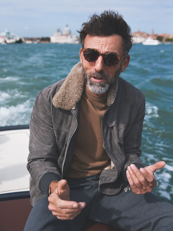 Light grey suede and beige shearling jacket, Brunello Cucinelli; camel wool jumper, Moncler; slate grey wool trousers, AMI; amber tortoise and tobacco lenses sunglasses, The Bespoke Dudes at The Rake. Sea green leather belt, property of The Rake.