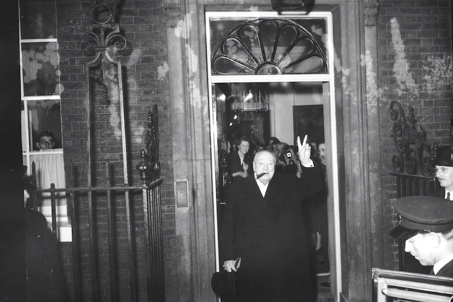 With his fingers raised in the familiar V sign, Churchill leaves No.10 Downing Street for the last time, 1955.