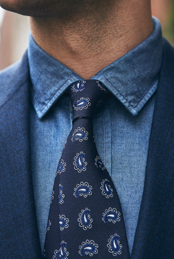 A denim shirt can break up the formality of a suit. Here is Salvatore Piccolo’s example, paired with a printed silk tie and indigo suit jacket.