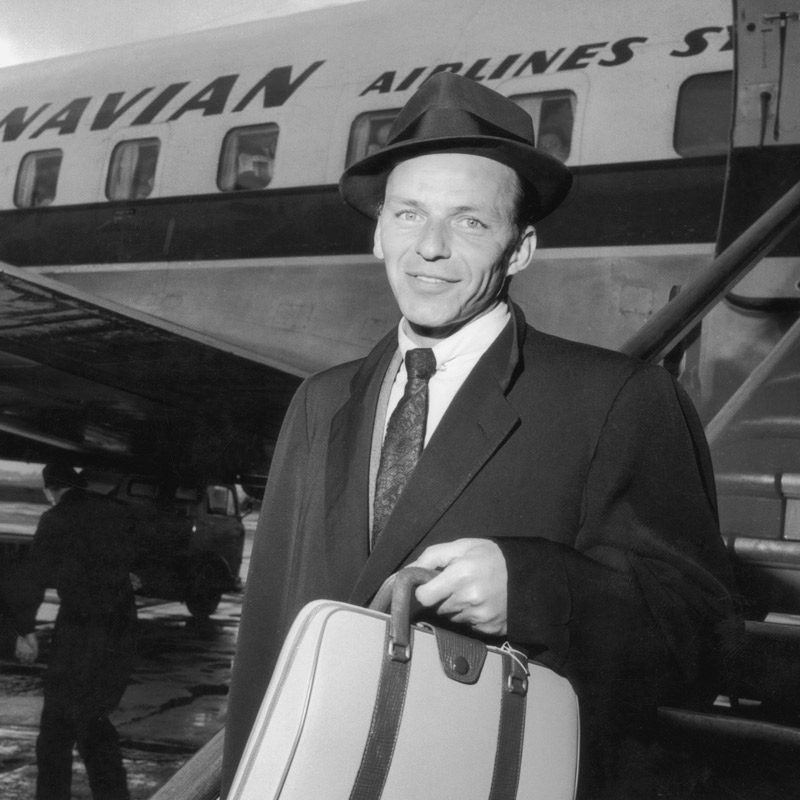 Frank Sinatra arrives in London, briefcase in hand, in 1956.