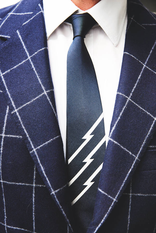 This suit and tie combination gleefully links heritage and modernity. The suit is a chalkstripe navy suit from legendary Italian tailor Caraceni, demonstrating exquisite taste when looking beyond Savile Row. The tie is a well paired Uniform Experiment in collaboration with Fragment Design's Hiroshi Fujiwara.