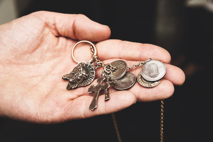 This necklace has miscellaneous gewgaws attached, all containing sentimental value, including his children's fingerprints, Japanese coins, his wedding ring, and some crucifixes. As George puts it, 