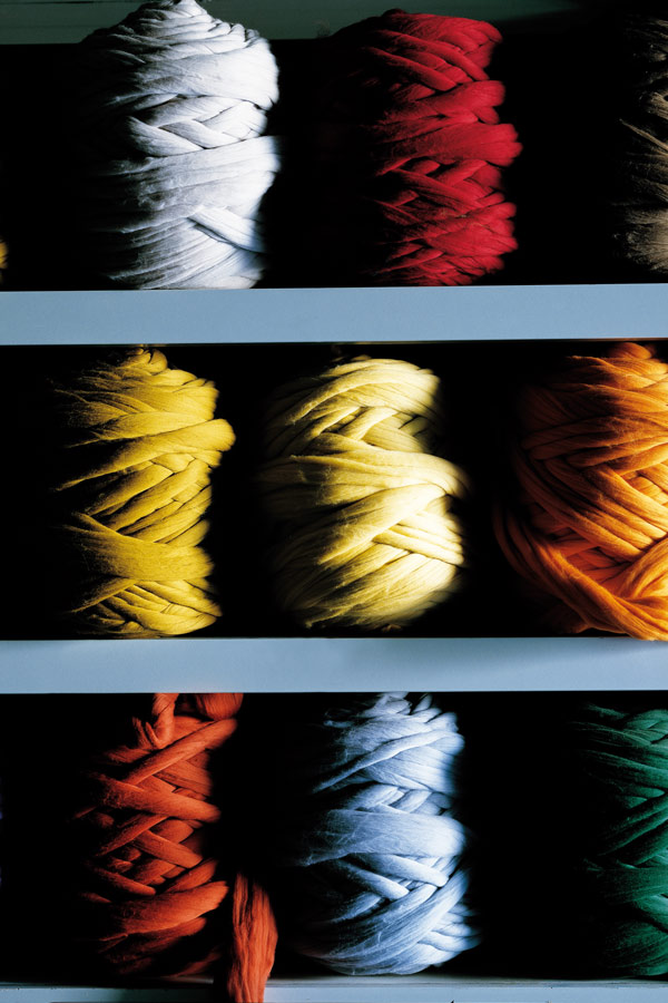 Dyed bobbins of yarn ready to be applied to the warping beam. Photograph by Luke Carby.