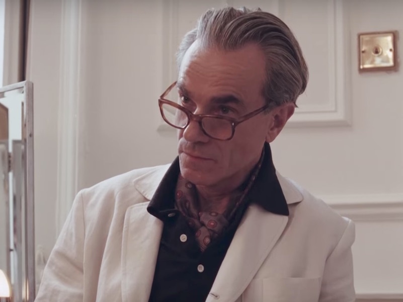 Peering over his tortoiseshell glasses in his workshop, wearing a brushed cotton polo and foulard beneath his staff jacket.