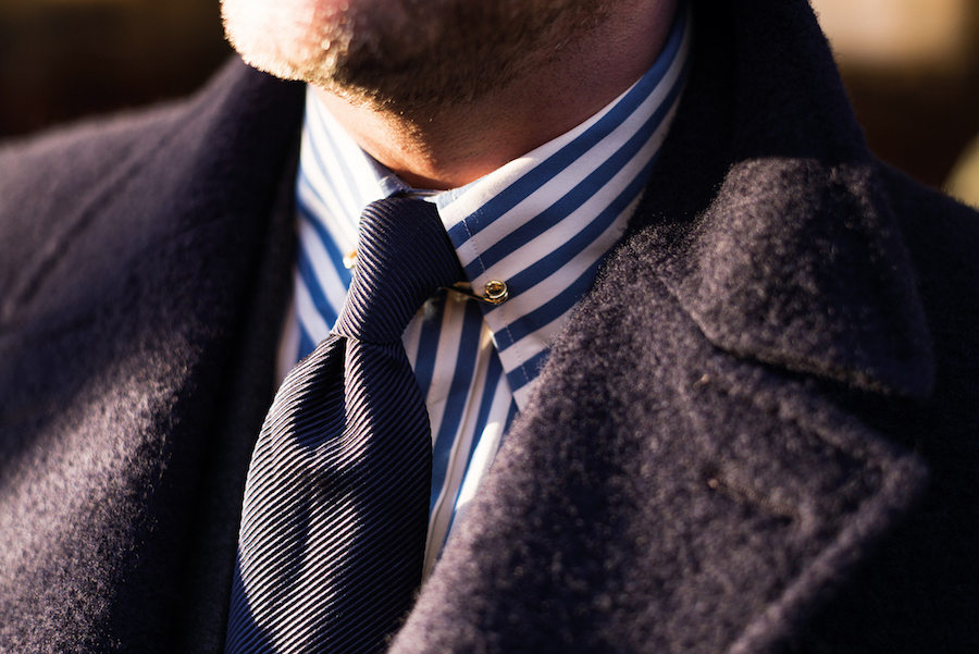 A ribbed tie adds texture and results in the formation of a small pleat beneath the knot and is further lifted by a gold collar pin. Photograph by Luke Carby.