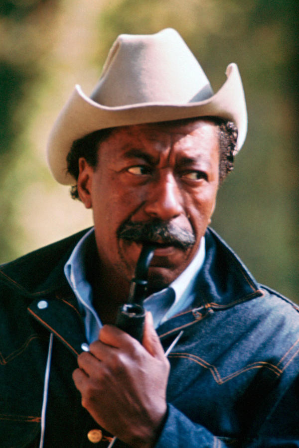 Parks wears a denim jacket over a short-sleeved shirt paired with a cowboy hat and his signature pipe on set of The Learning Tree, 1969. Photograph by Alamy.