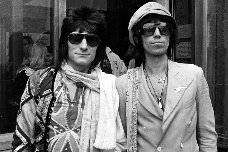 Wearing a whimsical ensemble including a double-breasted jacket, large sunglasses and a leather baker boy cap with fellow band member Ron Wood, 1976. Photograph by T FITZPATRICK/REX/Shutterstock.