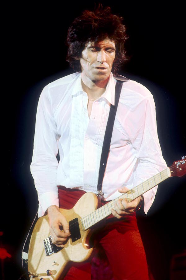 Richards pairs a white dress shirt with slim-fitting red trousers to perform while on tour in England, 1979. Photo by Andre Csillag/REX/Shutterstock.