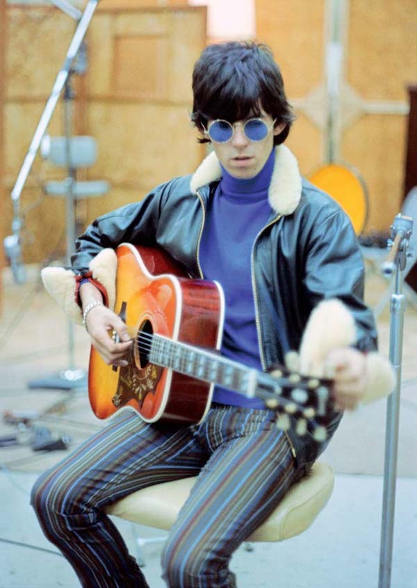 Wearing a shearling collar leather jacket with a violet roll neck and striped trousers while recording at RCA Studios in Hollywood, 1965.