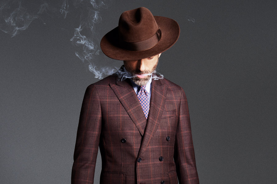Brown wool Prince of Wales check, double-breasted jacket, Gieves & Hawkes; white and blue stripe cotton shirt, Caruso; blue and red floral foulard unlined silk tie, Francesco Marino at The Rake; chocolate brown felt Louisiana fedora, Lock Hatters.