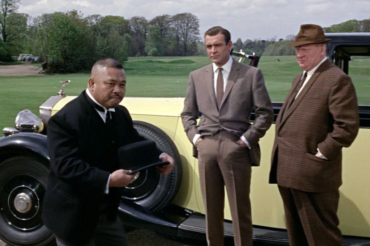 Connery's brown hacking jacket is paired with slightly contrasting flat-front trousers, off-white spread collar shirt and a slim, brown silk knit tie.