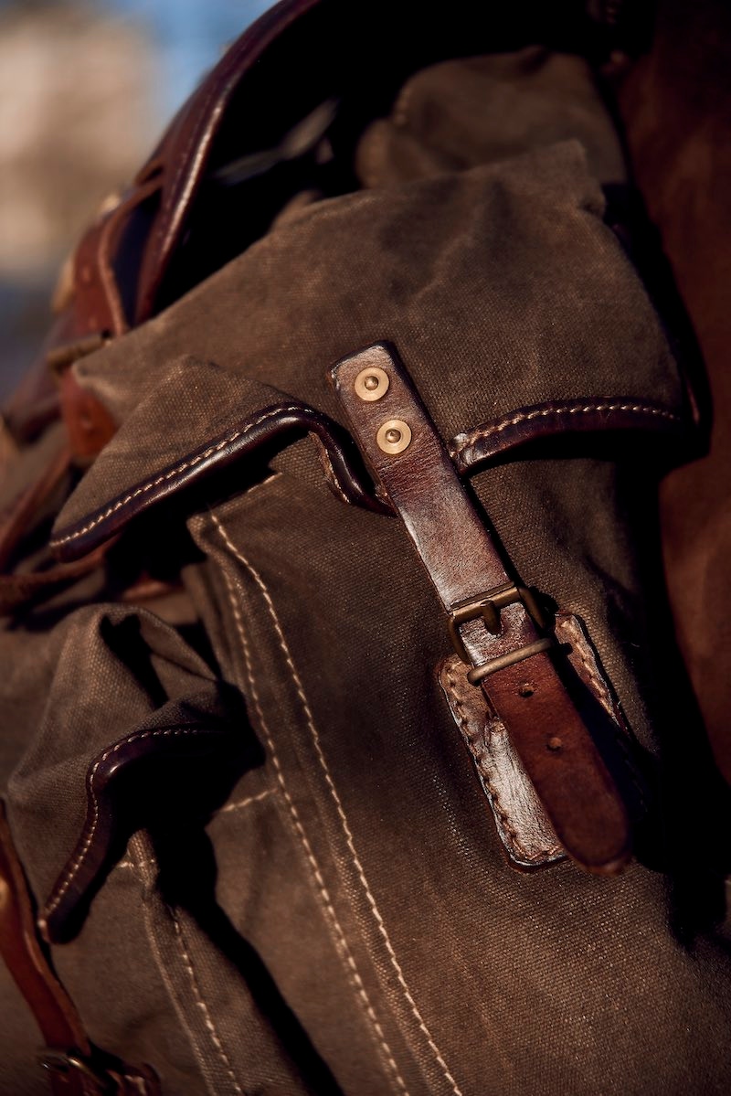 There are two cowhide leather flap pockets that are fastened with brass buckles.