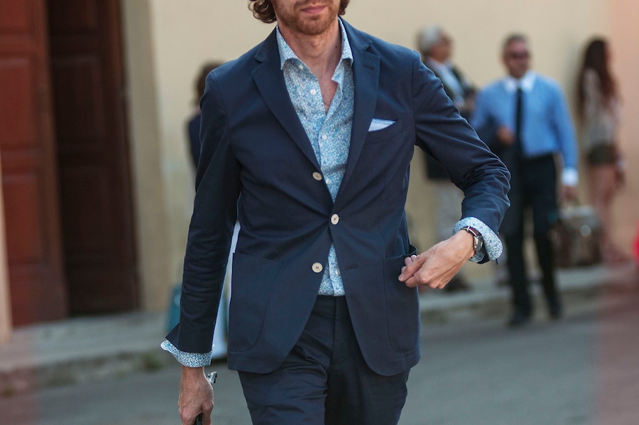 A tonal ensemble demonstrated at Pitti Uomo which pairs a blue floral shirt with a navy single-breasted suit. Photograph by Guerrisms.