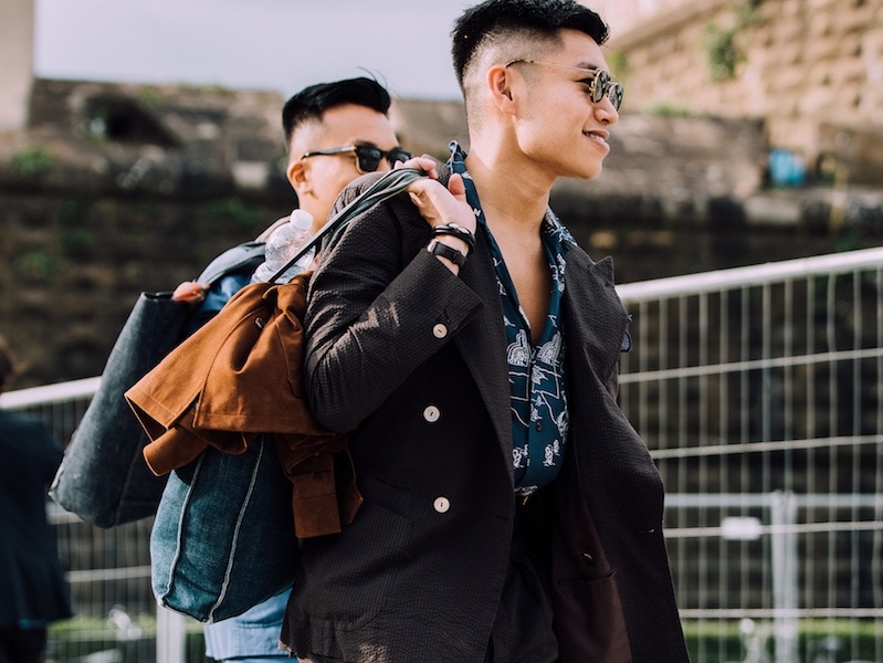 A chocolate brown double-breasted Seersucker suit worn with a camp-collar shirt and denim tote bag.