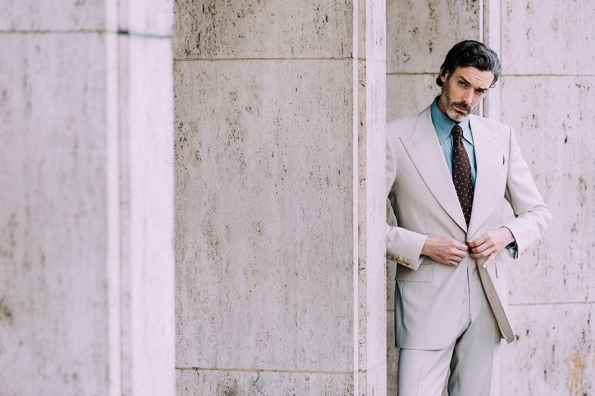 A neutral tone suit such as this one by Edward Sexton can be the perfect antidote to the charcoal grey work suit, especially when you add refreshing elements such as a blue denim or linen shirt and a contrast burgundy tie.