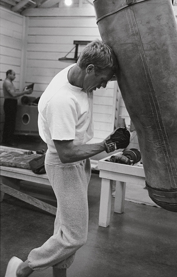 Steve McQueen gives the heavy bag some grief in a pair of grey cotton sweatpants.