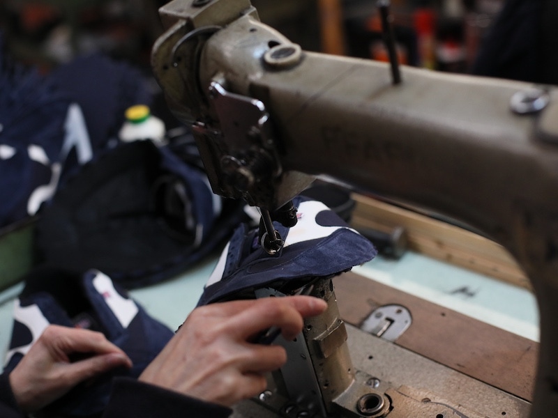 The uppers and quarters are then sewn together using a Singer sewing machine.