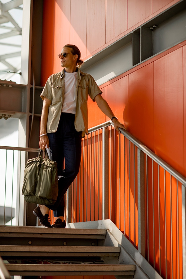 A pair of high-waisted navy cropped trousers are dressed down with a casual two-pocket janitor shirt. The peep of ankles and arms give the look a nicely rounded finish.