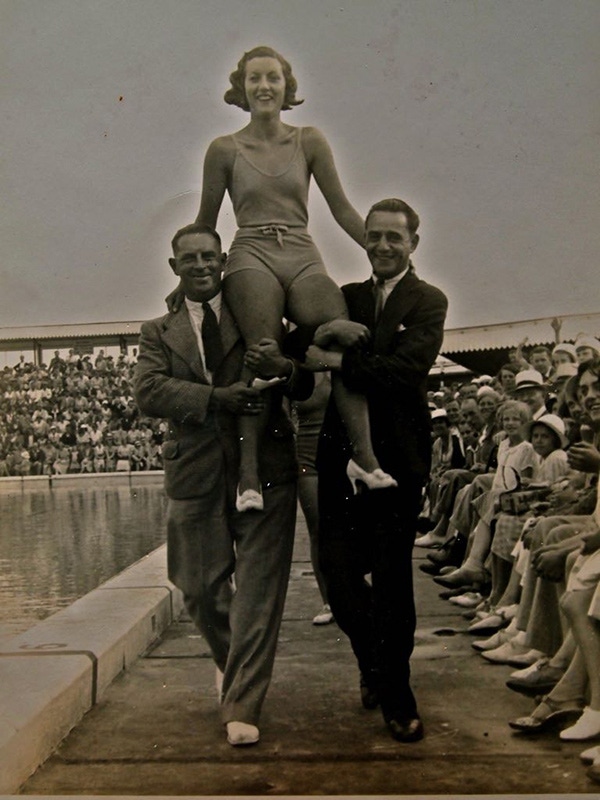 Stacey Wood's grandmother Joan pictured here hitching a ride on the shoulders of two suited gentlemen.