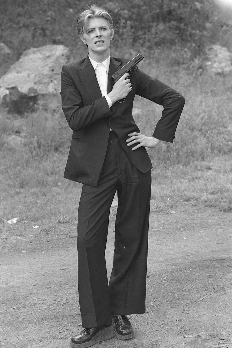 Bowie accessorises his oversized suiting with a gun for an accent of devil-may-care insouciance. Photograph by Alamy.