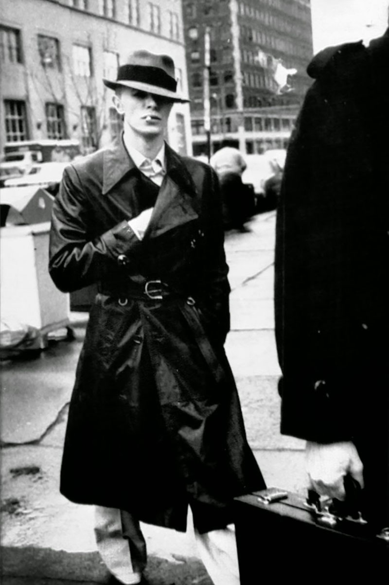 Bowie wearing a trench coat outside court, where he was answering drug charges in 1976.