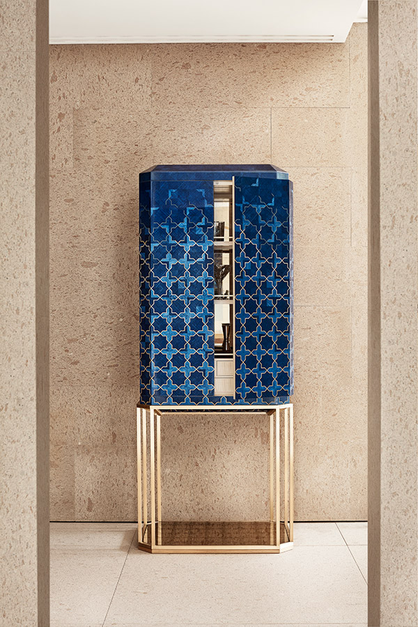 The Girih Cabinet explores Islamic pattern through detailed wooden marquetry in brilliant sapphire blue and rich gold tones. The chest is cradled by a metal base crafted with a brushed brass finish with a glass eglomisé panel at the base.