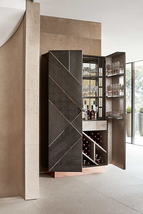 The charcoal oak exterior of this bar is segmented by a copper stringing pattern which directs the path of the wood grain.