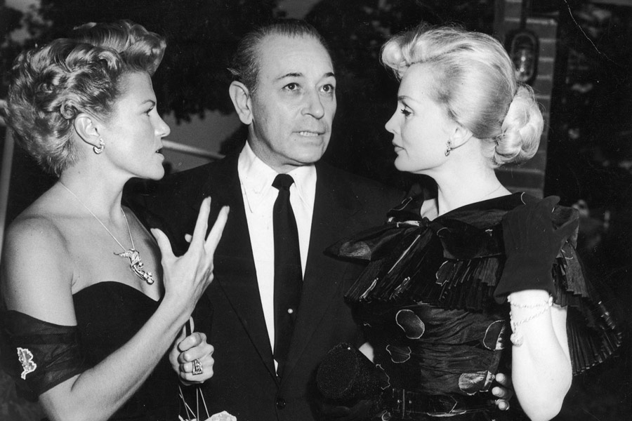 Chatting with  actresses Zoe Gail and Zsa Zsa Gabor at a farewell party he hosted before leaving England for Italy and the U.S., 1952. Photograph by Getty Images.