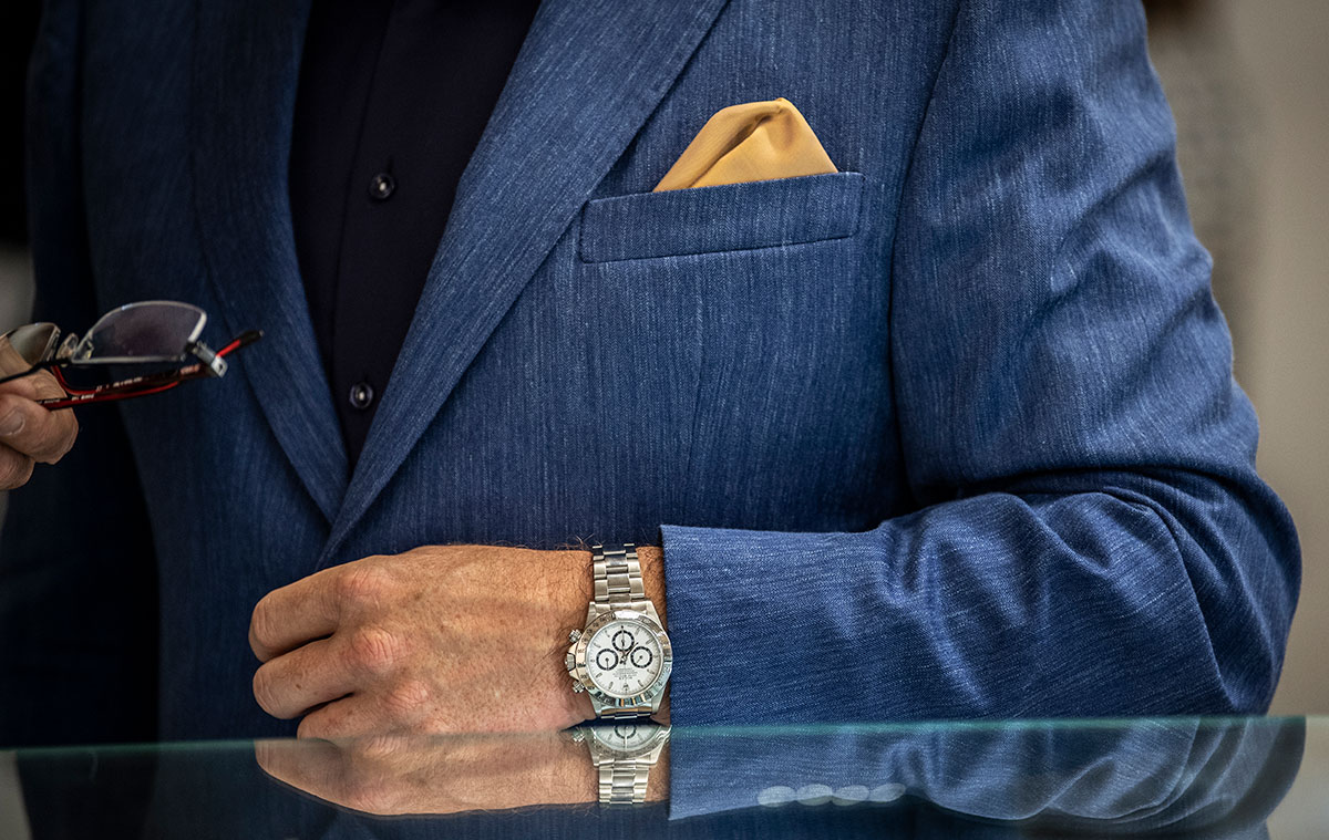 A Rolex Daytona beautifully offset by a striking combination of blue suit and contrast yellow pocket square.