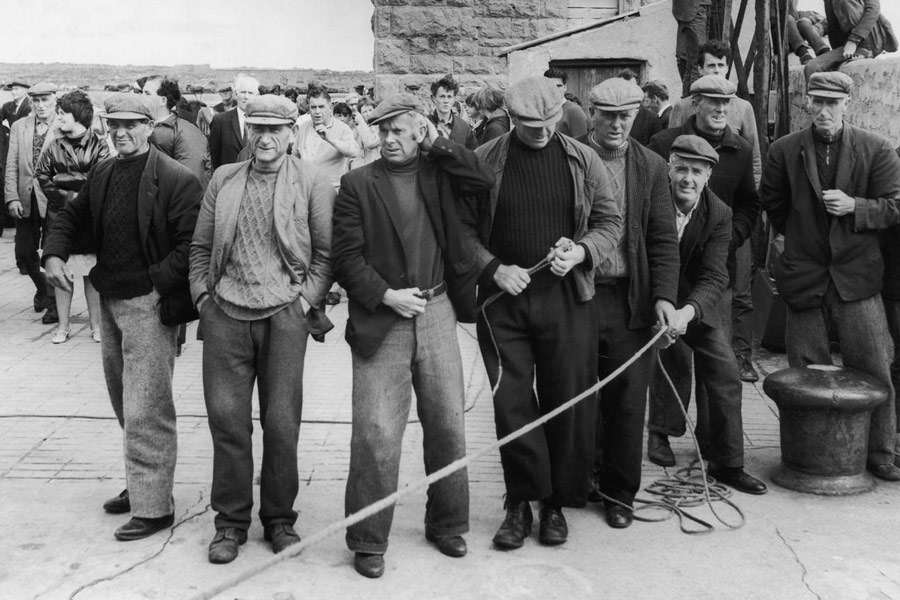 Men of the Aran Islands wear decorative knitted sweaters at a ceremony. Photograph by Alamy.