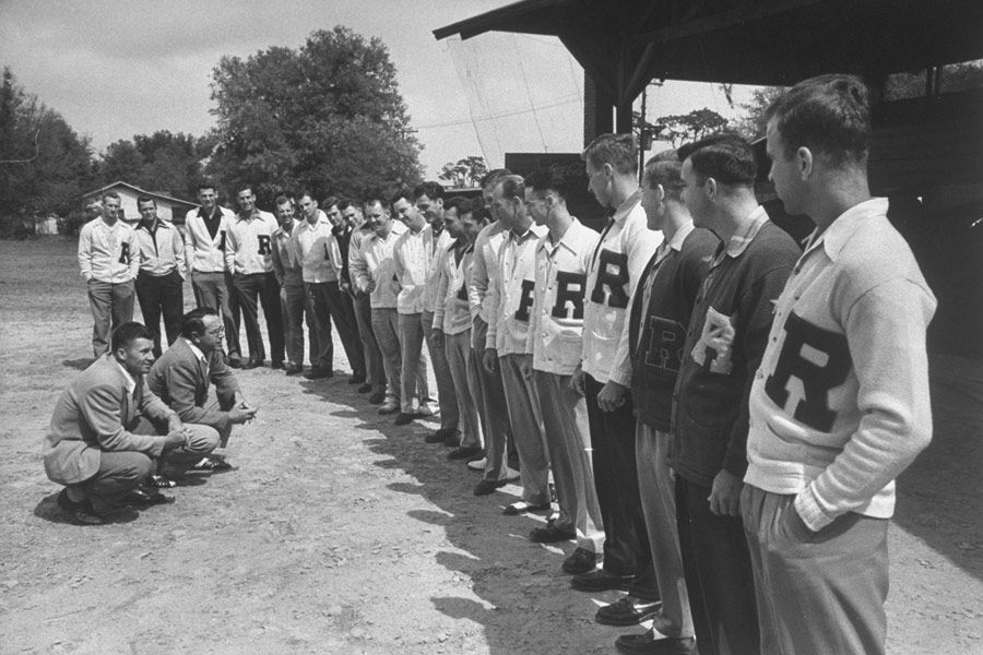 Football players line up in front of their coach. Photograph by Getty Images.