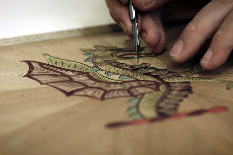 Hand-drawing the designs onto each board entails an intensive process.