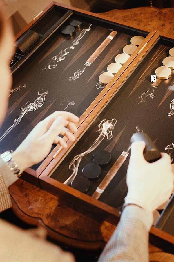 Alexandra Llewellyn's Black and Brown Wood Cigar Backgammon Set opens to reveal swirling smoke and cigars amongst triangles of printed tobacco leaves.